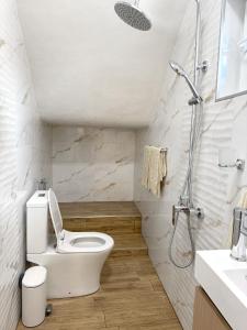 a white bathroom with a toilet and a shower at Nicola`s Apartment in Sozopol +9 photos