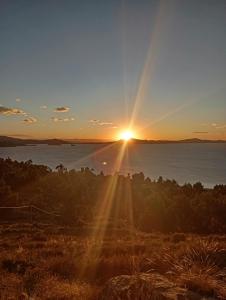 a sunset over a body of water with the sun setting at Hospedaje Mamani de isla amantani in Puno