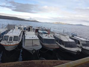 a group of boats docked at a dock in the water at Hospedaje Mamani de isla amantani in Puno