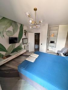 a bedroom with a blue bed and a chandelier at White Villas Koblevo in Koblevo +53 photos