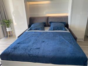 a bed with a blue comforter and two blue pillows at Studio cosy avec terrasse, vue mer in Quiberon