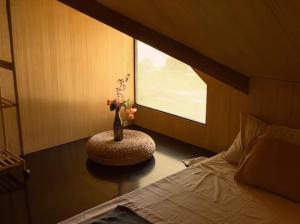 a bedroom with a bed and a vase with flowers in it at Rodeo Sun Hotel in General Luna