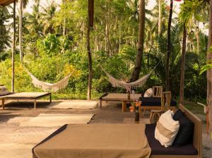 a patio with hammocks and chairs and tables and trees at Rodeo Sun Hotel in General Luna +14 photos