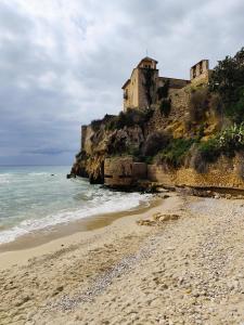 a castle on top of a cliff next to the ocean at Apartamento Altafulla in Altafulla +3 photos