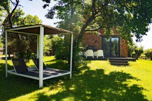 a gazebo and chairs in a yard at Płowce 7 - Mazurski dom z basenem i SPA in Płowce