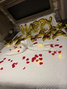 a white bed with a happy anniversary sign and red flowers at Sunset Combate in Cabo Rojo
