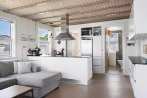 a living room with a couch and a kitchen at LF15135-Farso-Strandvejen-35-B in Hvalpsund