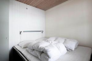 a white room with a bed with white pillows at LF15135-Farso-Strandvejen-35-B in Hvalpsund