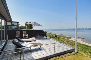 a house with a deck with a view of the water at LF15135-Farso-Strandvejen-35-B in Hvalpsund +16 photos