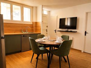 a dining room with a table and chairs and a television at Appart T3 Stratégique - Parking - Accès A64 in Portet-sur-Garonne