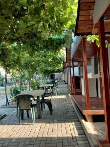 a patio with tables and chairs and a building at Casa Mihai in Costinesti