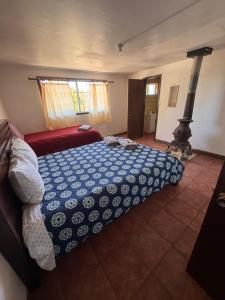 a bedroom with a bed with a blue and white blanket at Casa Andres in Camalú