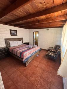 a bedroom with a bed and a chair in it at Casa Andres in Camalú