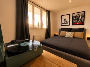 a bedroom with a bed with a vinyl record on it at Appart T3 Stratégique - Parking - Accès A64 in Portet-sur-Garonne
