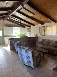 a living room with couches and a table and a kitchen at Rancho Meling Casa Felipe in Camalú