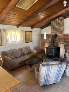 a living room with a couch and a wood stove at Rancho Meling Casa Felipe in Camalú