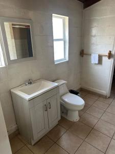 a white bathroom with a toilet and a sink at Rancho Meling Casa Felipe in Camalú