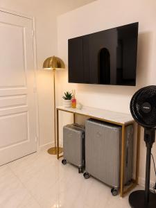 a room with a desk with a television on a wall at Studio Chic - Centre-Ville in Sablé-sur-Sarthe