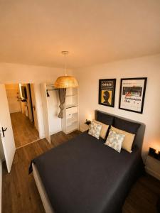 a bedroom with a black bed in a room at Appart T3 Stratégique - Parking - Accès A64 in Portet-sur-Garonne