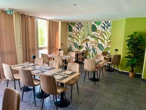 a dining room with tables and chairs and a plant at Le Clos de Sangonis in Saint-André-de-Sangonis