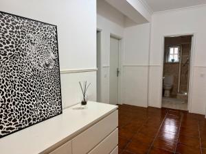 a white room with a black and white painting on the wall at Casa do Rio Ceira Góis in Góis +25 photos