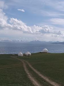 two domes in a field next to the water at Sonkol-resort in Song-Kul