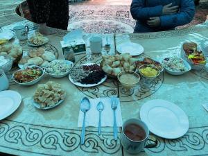 a table topped with plates and bowls of food at Sonkol-resort in Song-Kul