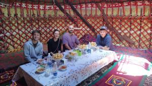 a group of people sitting around a table at Sonkol-resort in Song-Kul