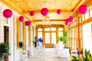 a room with pink lanterns and tables and chairs at The Brandon Inn in Brandon