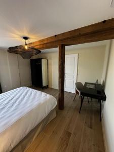 a bedroom with a bed and a table and a desk at Suite Véloscénie in Lèves