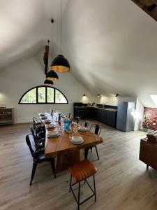 a dining room with a wooden table and chairs at Suite Véloscénie in Lèves
