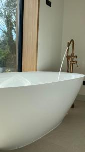 a white bath tub sitting in a room with a window at Acouga in Miñortos +35 photos