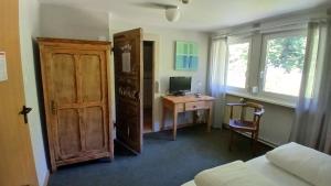 a bedroom with a desk with a computer and a door at Les2Châteaux in Windstein