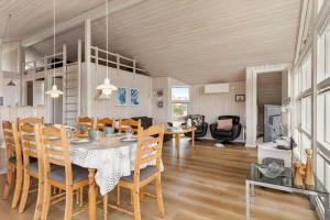 a dining room and living room with a table and chairs at 402-Harboore-Flyvholmvej-23 in Harboør