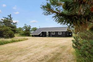 a black house with a large yard in front of it at 402-Harboore-Flyvholmvej-23 in Harboør