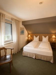 a bedroom with a large white bed and a window at Les2Châteaux in Windstein