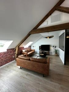 a living room with a couch and a table at Suite Rivière in Lèves