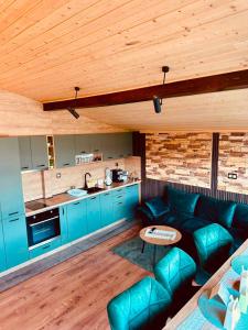 a living room with a blue couch and a kitchen at Къща за гости Шанови in Gʼovren