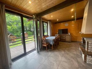 a dining room with a table with chairs and a television at Gawra Werlas in Werlas