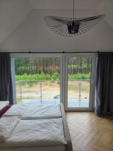 a bedroom with a bed and a large window at Dom nad Zbrzycą MODRY in Swornegacie