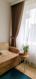 a living room with a couch and a table with a window at Alka guest house in Palanga +2 photos