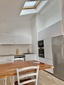 a kitchen with a wooden table and a skylight at L'Annexe de l'Etape Basque in Bidart +8 photos