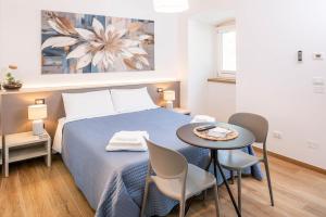 a bedroom with a bed and a table with chairs at L'angolo del Forte in Rivoli Veronese