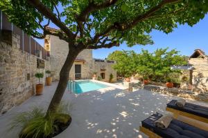 a courtyard with a tree and a swimming pool at Villa Diamant 1860 in Monókhoron