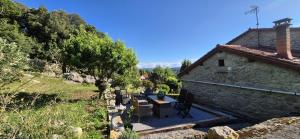 a stone house with a table and chairs outside at Casa Coba in Camijanes