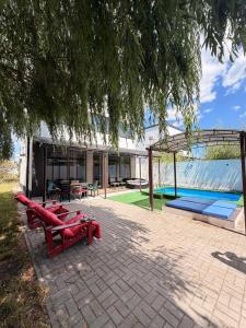 a house with a swimming pool and red benches at White Villas Koblevo in Koblevo