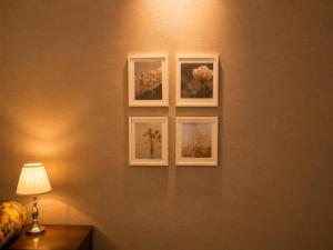 three framed photographs on a wall with a lamp at Hotel Copacabana Stay in Serra