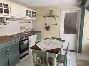 a kitchen with a table and a table and chairs at Macskakő Apartman in Szentendre