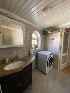 a bathroom with a sink and a washing machine at Macskakő Apartman in Szentendre