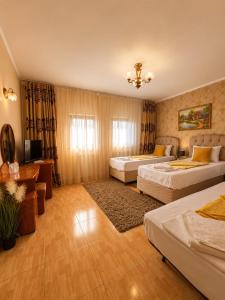 a hotel room with two beds and a television at Hotel Casa Italia in Calafat